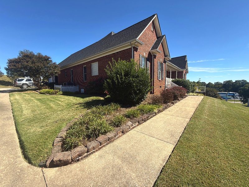 Mowed grass and a clean sidewalk edge beside established foundation beds.